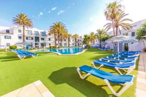 - une rangée de chaises longues bleues à côté de la piscine dans l'établissement Vibra Blanc Cottage Apartmentos - 3SUP, à Sa Caleta