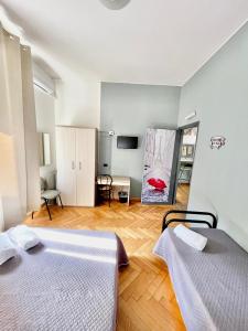 Habitación con 2 camas y una pintura en la pared. en Bovisa House B&B private rooms en Milán