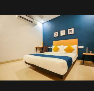 a bedroom with a large bed with a blue wall at Nilansh homes and hotels in Lucknow