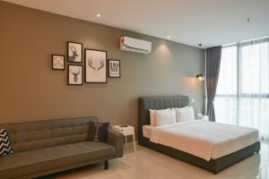 una camera da letto con un letto e un divano di Atria Sofo Suites Petaling Jaya a Petaling Jaya