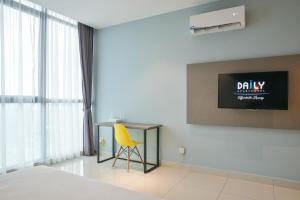 una camera con letto, scrivania e sedia gialla di Atria Sofo Suites Petaling Jaya a Petaling Jaya