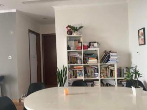 a white table and chairs in a room with a book shelf at Park 12 Homestay in Hanoi