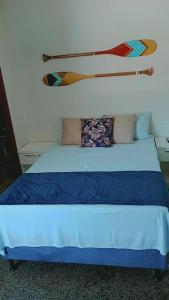 1 cama con sábanas y almohadas azules en una habitación en Segunda Casa- Seu cantinho na Praia do Morro em Guarapari - Quartos suítes 2 até 4 pessoas, en Guarapari