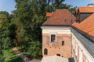 een raam aan de zijkant van een bakstenen gebouw bij Zamek Uniejów in Uniejow