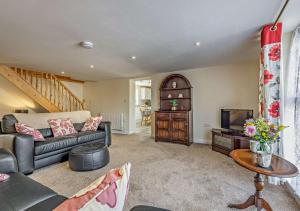 a living room with a couch and a tv at Yr Annexe Mermur y Nant in Aberystwyth