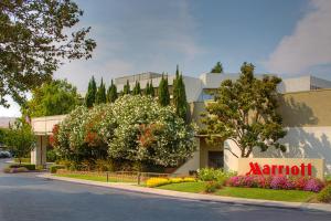 a sign in front of a building with flowers at Pleasanton Marriott in Pleasanton