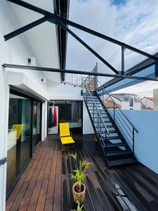 une terrasse avec un escalier et des chaises jaunes sur une maison dans l'établissement LOFT Triplex 300m² à 10 min PARIS/EXPO, à Malakoff