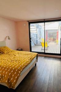 - une chambre avec un lit et une vue sur une terrasse dans l'établissement LOFT Triplex 300m² à 10 min PARIS/EXPO, à Malakoff