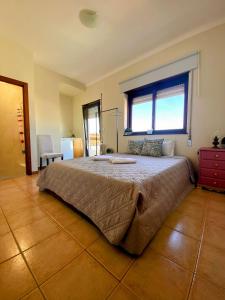a bedroom with a large bed with a large window at houses&halfhouses historic street in Caminha