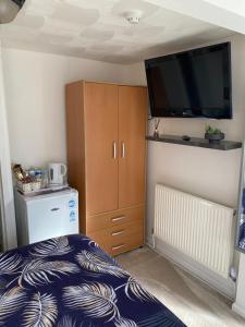 a bedroom with a bed and a flat screen tv at The Hideaway!! Skegness ground floor room free parking in Skegness