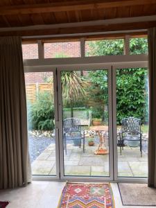 an open patio door with a table and chairs outside at The Barn in Romsey