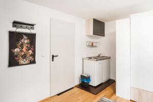 een kamer met witte muren en een keuken met witte kasten bij Cocoon Studio in Lochau