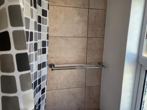 a shower with a tiled wall and a shower curtain at Studio in Greenhithe in Greenhithe