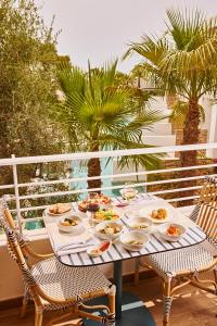a table with plates of food on a balcony at TRS Ibiza Hotel - Adults Only in San Antonio +37 photos