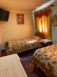 a hotel room with two beds and a window at Residencial 10 de Noviembre in Potosí