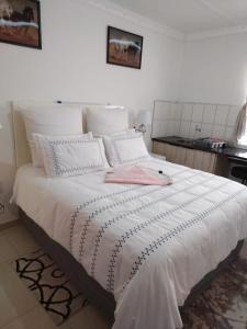 a white bed with a pink towel on top of it at 4 Centenary Road Ixopo in Ixopo