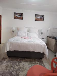 1 dormitorio con 1 cama y 1 silla roja en 4 Centenary Road Ixopo en Ixopo