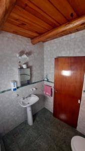 La salle de bains est pourvue d'un lavabo et d'une porte en bois. dans l'établissement CABAÑAS HORNERO, à San José del Rincón
