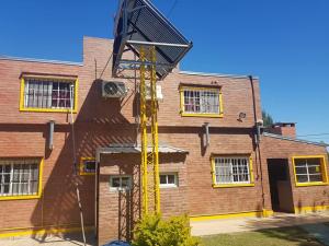 a yellow crane is on the side of a brick building at CABAÑAS HORNERO in San José del Rincón