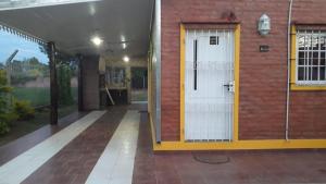 Cette chambre est dotée d'une porte blanche et d'un mur en briques. dans l'établissement CABAÑAS HORNERO, à San José del Rincón