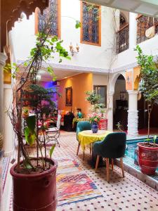 sala de estar con mesa, sillas y plantas en Riad Zahri, en Marrakech