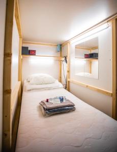 a small bedroom with two beds and a window at Capsule Hostel Logistic Vilnius in Vilnius