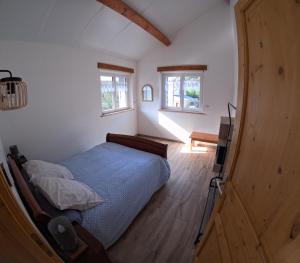 een slaapkamer met een bed en een televisie. bij Gîte des quatre saisons in Thilay