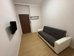 een kleine woonkamer met een bank en een luidspreker bij Xiridia House in Turijn