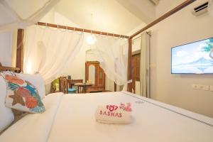 a bedroom with a bed with a tv on the wall at Sashas Holiday Village in Vagator