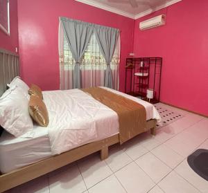 1 dormitorio con 1 cama grande y paredes de color rosa en Venice Raudhah Guest House, en Lumut