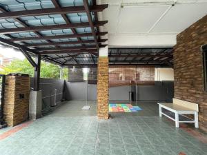 a large room with a brick pillar and a table at Venice Raudhah Guest House in Lumut