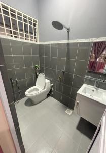 ein Bad mit einem WC und einem Waschbecken in der Unterkunft Venice Raudhah Guest House in Lumut