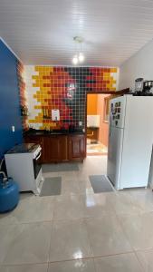 a kitchen with a white refrigerator in a room at Casa Amarela Alter in Alter do Chao