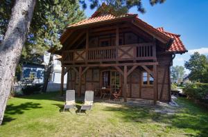 a log cabin with two chairs and a table at komfortables Haus mit Kamin, Sauna, Garten und Terrasse - Ferienhaus Windhuus in Wiek auf Rügen 