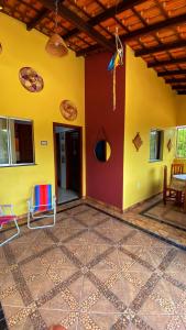 a room with a yellow wall and a table and chairs at Casa Amarela Alter in Alter do Chao