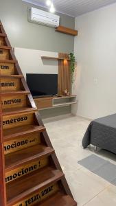 a staircase in a room with a bed and a television at Casa Amarela Alter in Alter do Chao