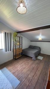 a bedroom with a bed and a wooden floor at Casa Amarela Alter in Alter do Chao