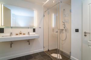a bathroom with a sink and a shower at Appartement Meeresleuchten - Nicolinenhof in Wenningstedt +28 photos