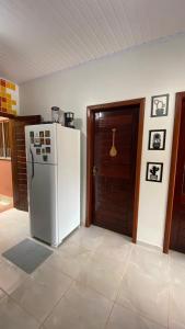 a kitchen with a white refrigerator and a door at Casa Amarela Alter in Alter do Chao