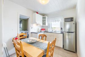 a kitchen and dining room with a table and a refrigerator at MB Guesthouse in Grímsnes og Grafningshreppur