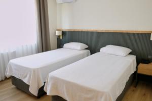 デニズリにあるGrand Keskin Otelのベッド2台が隣同士に設置された部屋です。