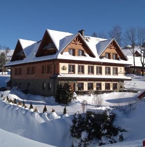 a large wooden house with snow on top of it at Vila Panorama in Ždiar