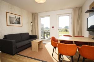 a living room with a couch and a table at moderne Ferienwohnung in ruhiger Lage mit Terrasse - Wreecher Idyll FeWo 02 in Wreechen