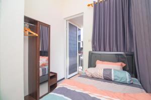 a bedroom with a bed and a window at Villa Cordoba D11 by Sans Villa in Batu +11 photos