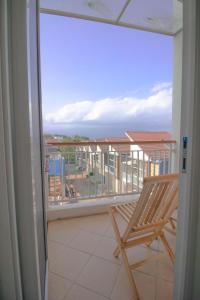 Un balcón con una silla y vistas al océano. en Villa Cordoba D11 by Sans Villa, en Batu