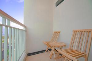 2 sillas y una mesa en el balcón en Villa Cordoba D11 by Sans Villa, en Batu