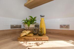 a cutting board with bread and a bottle and a plant at A spacious home from home with spectacular views in Heywood