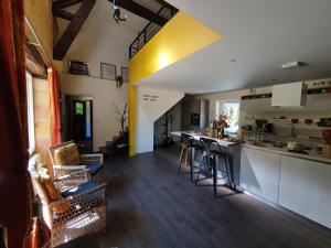 Una cocina y una sala de estar con un mostrador y una mesa. en Le Clos d'Ô Les Rapiettes maison proche Sarlat avec piscine privée, en Prats-de-Carlux