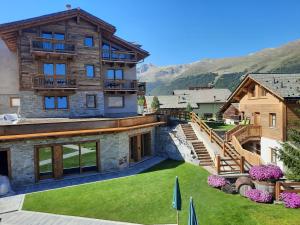 an image of a house with mountains in the background at Hotel del Bosco in Livigno