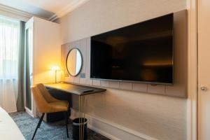 um quarto de hotel com uma televisão na parede em Crowne Plaza Manchester Airport, an IHG Hotel em Hale
